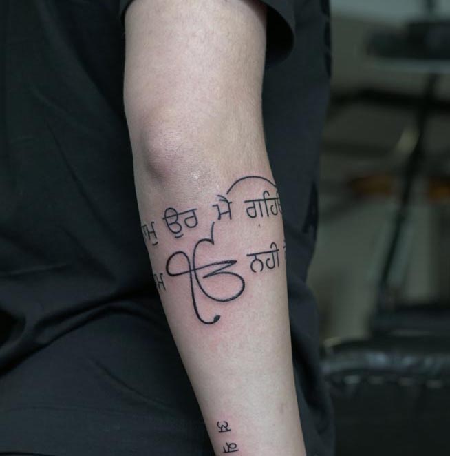 ek onkar symbol punjabi gurmukhi religious quote minimalist tattoo male forearm