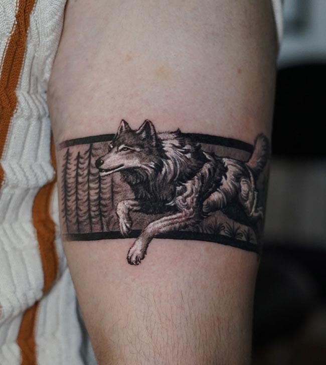 running wolf forest pine trees wildlife landscape scene armband tattoo male upper forearm