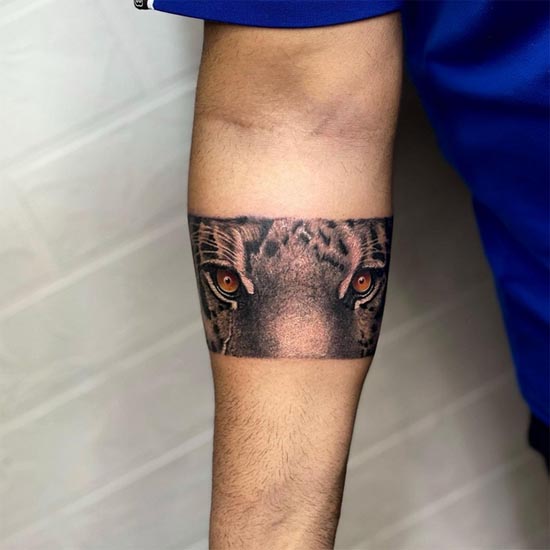 tiger face orange eyes stripes armband tattoo realistic male forearm