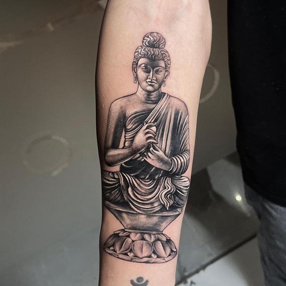 buddha sitting on round sitting stool statue tattoo design male forearm