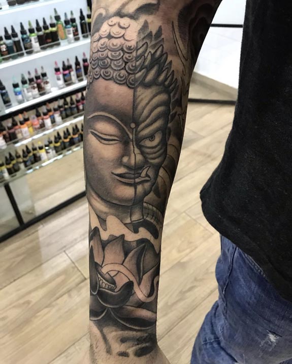 half buddha face half demon with lotus below tattoo male half sleeve