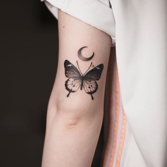 butterfly having night scene on wings with crescent moon tattoo design female outer bicep