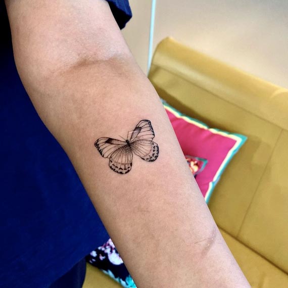 butterfly minimalist tattoo design female forearm