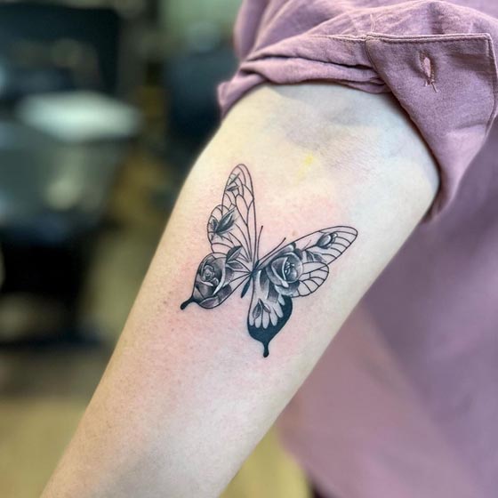 butterfly roses on wings tattoo black and grey girl forearm