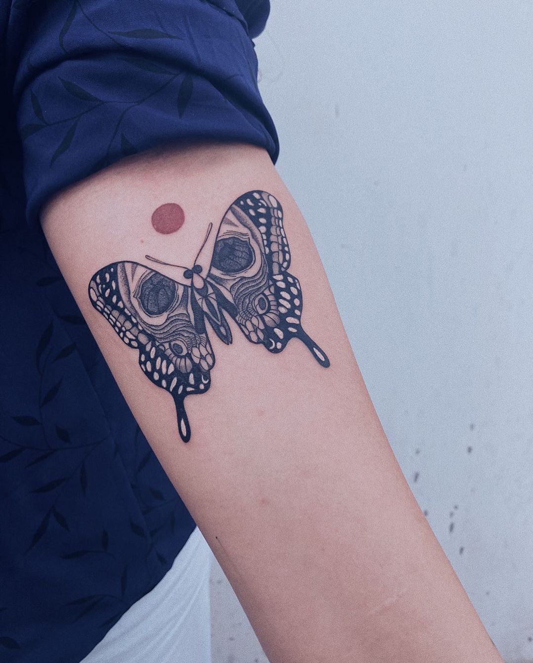 butterfly with skull on wings moon tattoo design female upper forearm