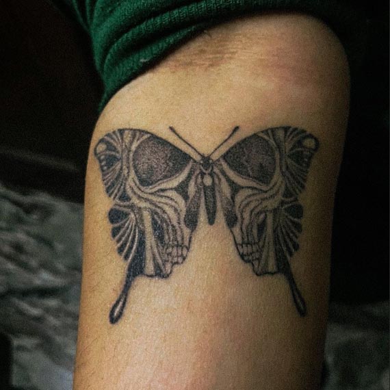 butterfly with skull on wings tattoo design male hand forearm