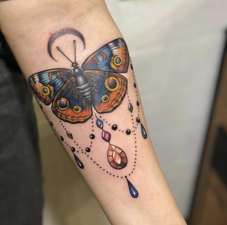 colored butterfly with jewellery and moon female forearm