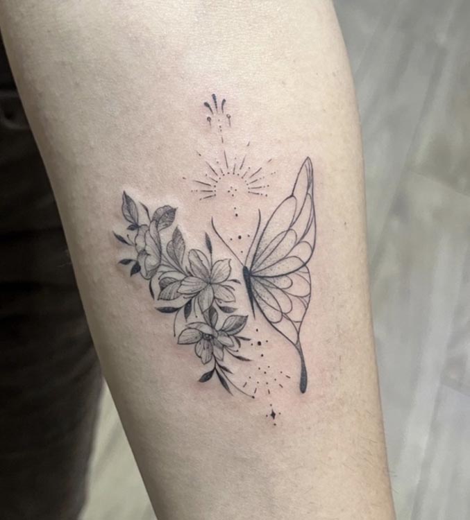 half butterfly flowers sun tattoo female forearm fine line