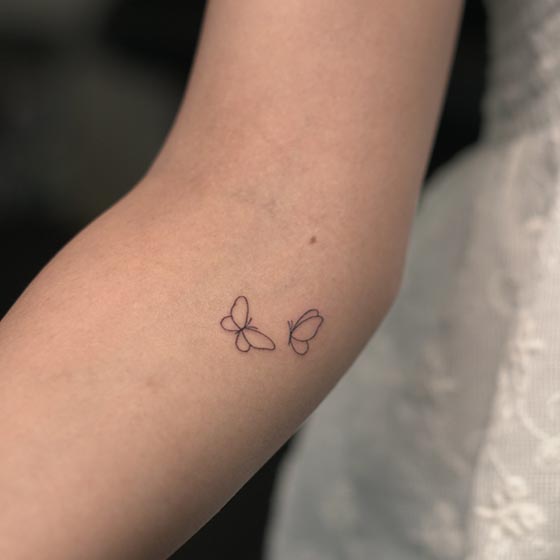 simple tiny 2 butterflies tattoo design fine female elbow