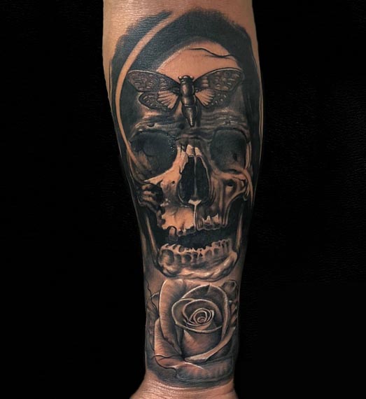skull rose butterfly tattoo male hand forearm and grey