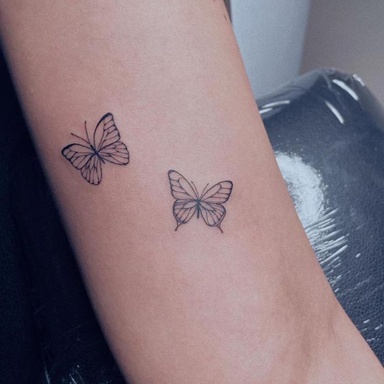tiny 2 butterfly tattoo design linework female outer bicep