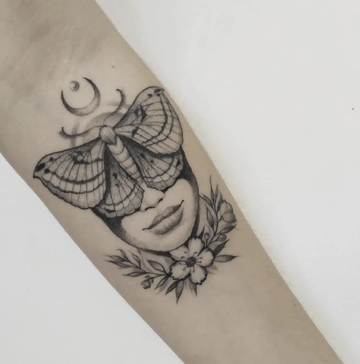 woman upper half face covered with butterfly with flowers moon tattoo female forearm
