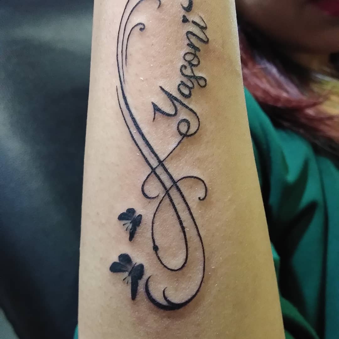 yasoni name tattoo with butterfly infinity pattern hand