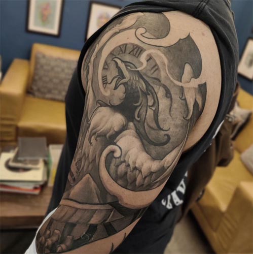 phoenix clock wings feathers mountains clouds smoke tattoo male shoulder bicep