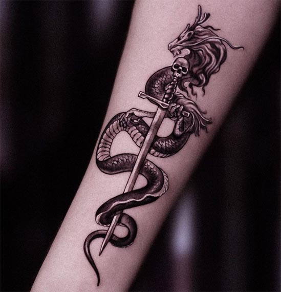 dragon holding sword pommel as skull tattoo design male hand forearm
