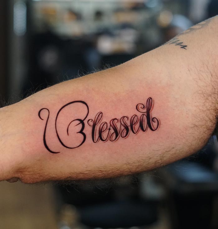ek onkar combined with word blessed calligraphy tattoo male bicep