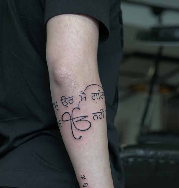ek onkar punjabi text armband tattoo man arm