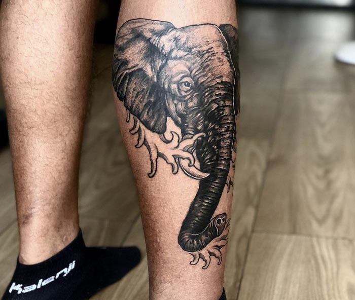 dark black elephant head tattoo on man calf