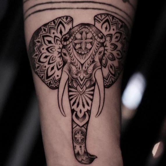 elephant head with intricate ornamental detail tattoo black grey forearm
