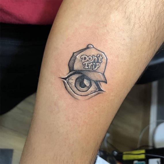 cap with text dont trip and eye tattoo design male forearm