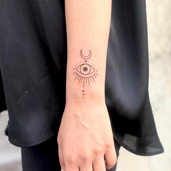 evil eye crescent moon tattoo design linework female forearm