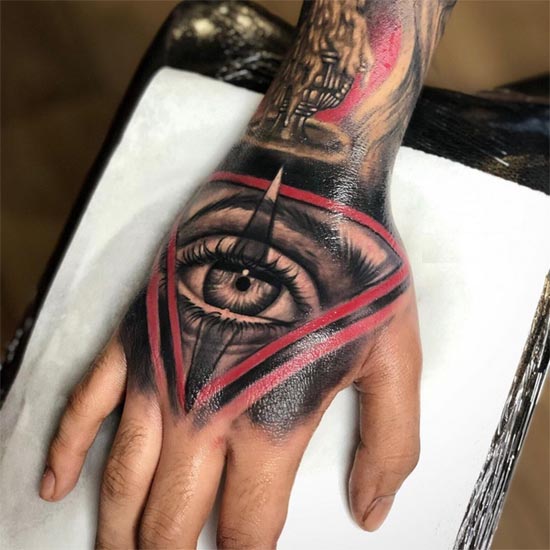 eye in red colored triangle with black background tattoo design male hand