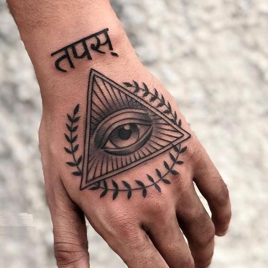 name tapas in hindi font eye in double triangle laurel wreath tattoo male hand