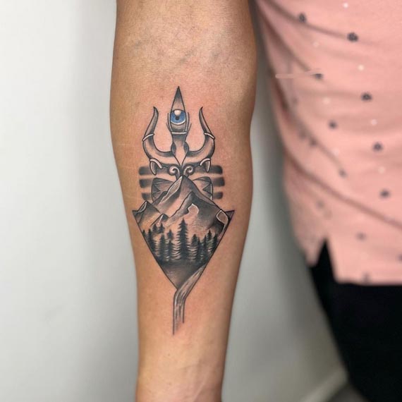 trishul eye mountains river trees tattoo black and grey male forearm