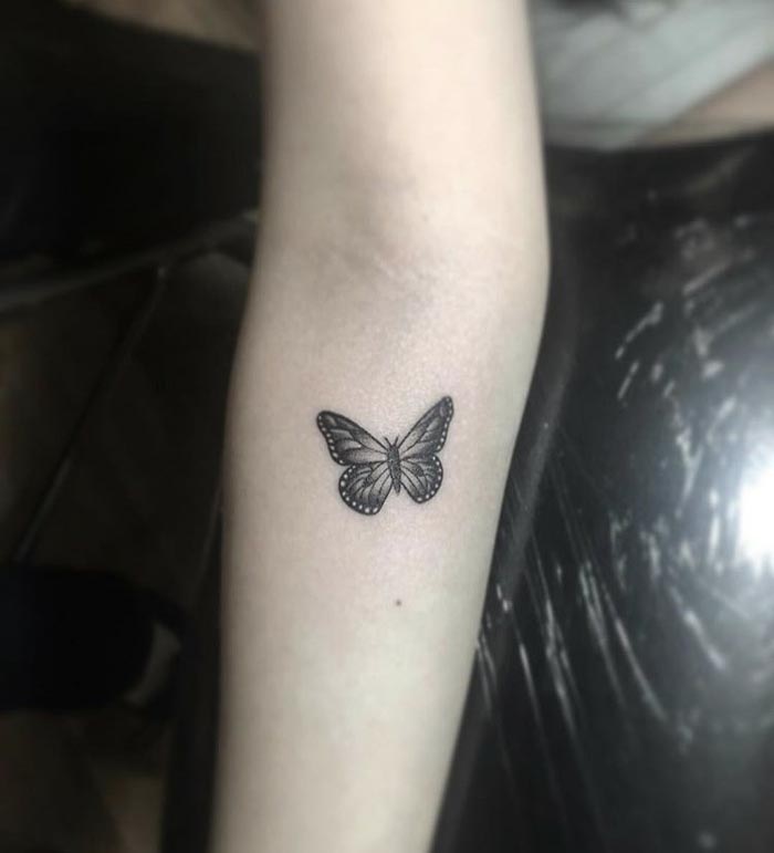 cure butterfly tattoo on forearm