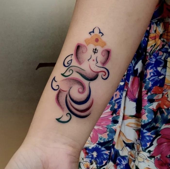 colored ganesha tatoo on female hand