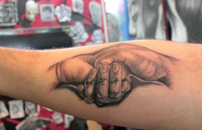 holding hands tattoo on arm