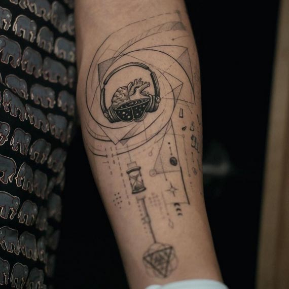 headphone on half brain half heart with geometric pattern tattoo male forearm