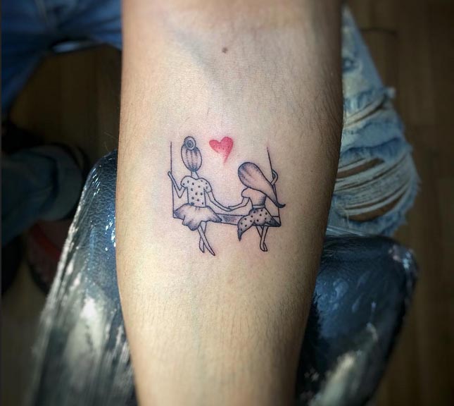 mother daughter sitting on hammock swinging and heart tattoo design male hand forearm