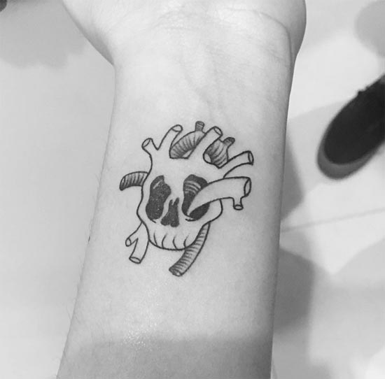skull heart tattoo minimalist female hand forearm