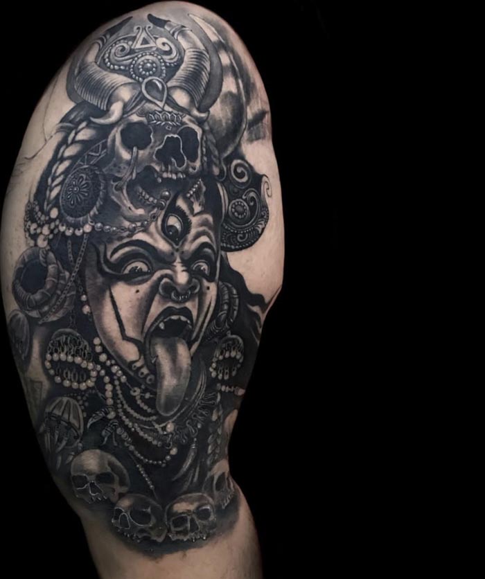 maa kali with skull headdress wearing skulls and gemstones garland tattoo male bicep