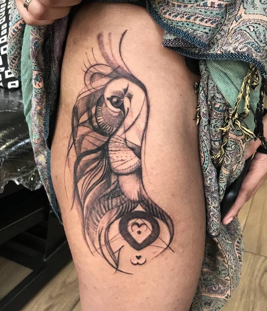 abstract lion eyes tattoo woman upper thigh