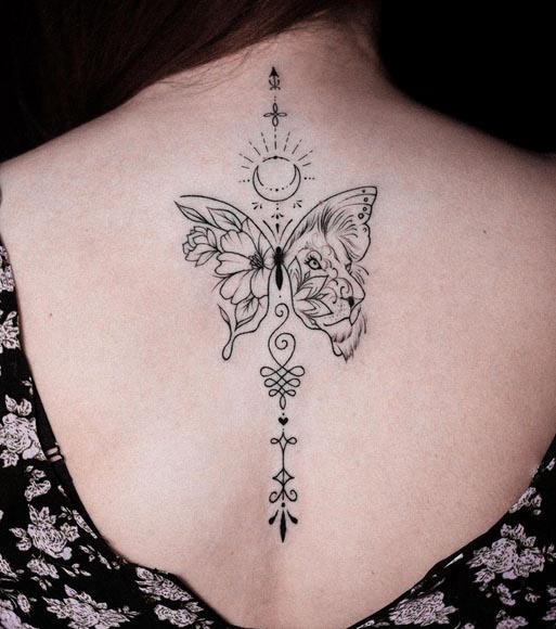 butterfly having lioness on one wing flowers on other with moon sun tattoo fine line female back