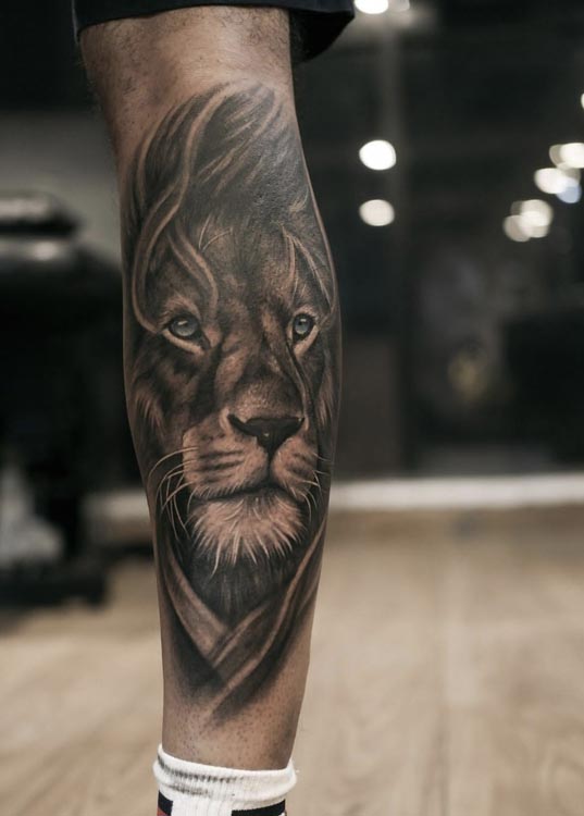 large lion head tattoo man calf black and grey