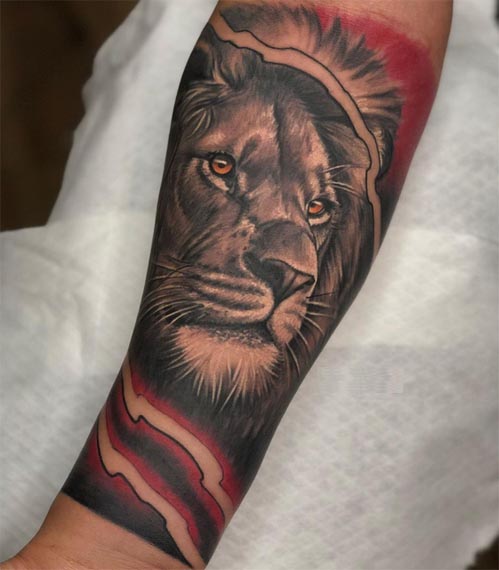 lion yellow eyes with background tattoo male hand forearm