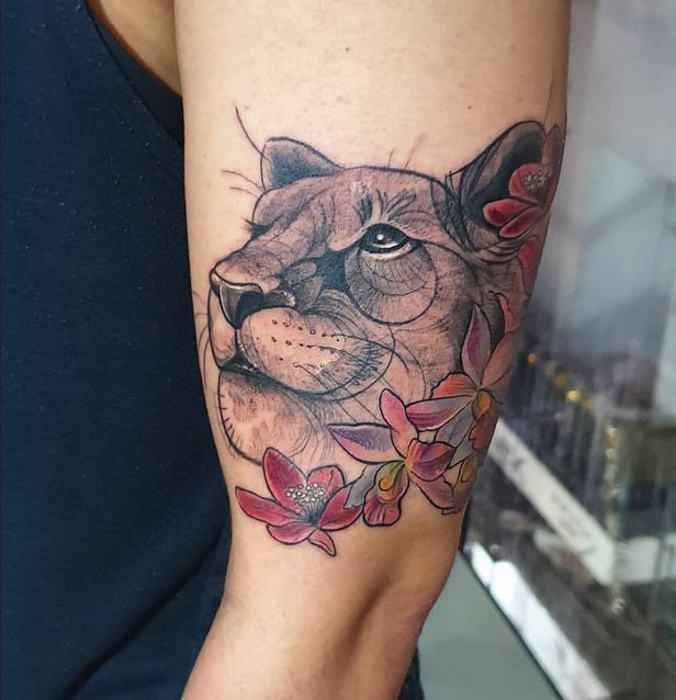 lioness face with flower tattoo man bicep