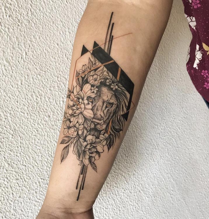 lioness head covered with flowers tattoo woman forearm