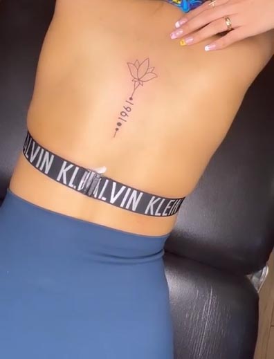 lotus flower with date small tattoo linework female back