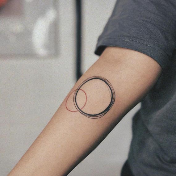 2 circles red black minimal geometry tattoo female forearm