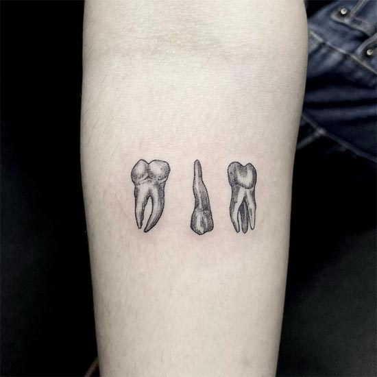 minimalist 3 teeth tattoo on female hand forearm