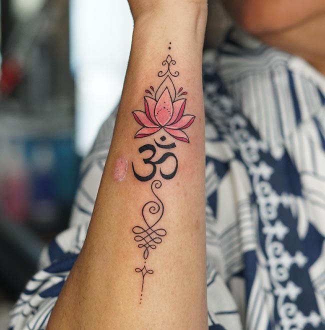 coloured lotus om unalome tattoo design female forearm