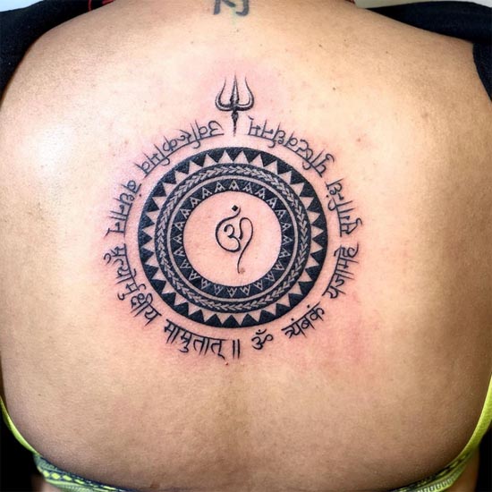 om in center mandala maha mrityunjaya mantra and trishul at top tattoo girl back
