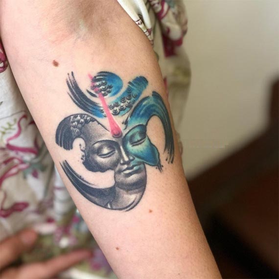 realistic buddha merged with om tattoo design female forearm