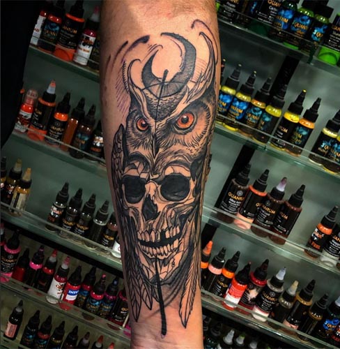 abstract skull and owl headdress tattoo male forearm