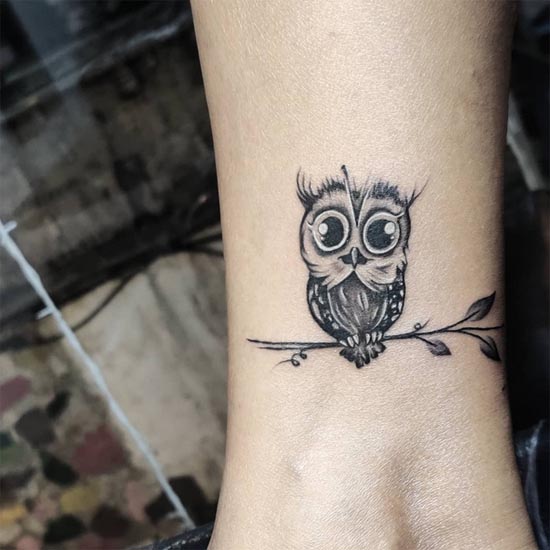 cute owl sitting on branch tattoo design female leg