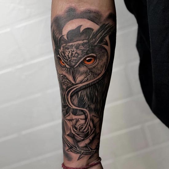 owl with orange eyes rose tattoo outer arm